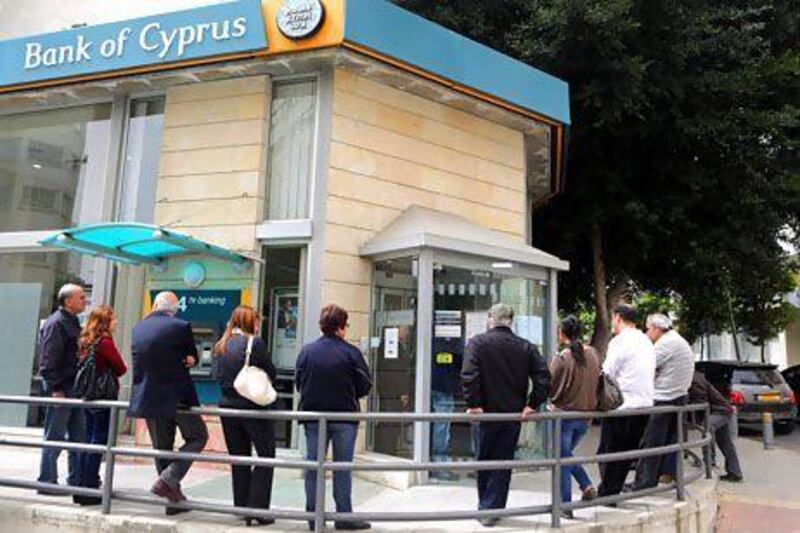 Despite public outcry and the scrapping of a plan to levy all bank accounts in Cyprus, accounts holding more than €100,000 will still be tapped into by the government to help to meet terms of an EU bailout. Above and below, Cypriots queue to withdraw money. Patrick Baz / AFP