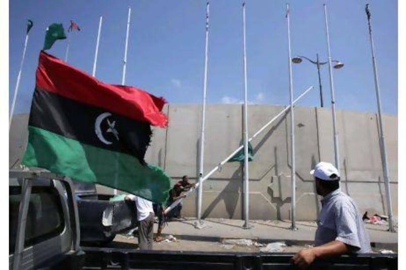 The Libyan rebellion's flag flutters as rebels pull down a pole bearing the old regime's green flag at the Abu Slim square in Tripoli.