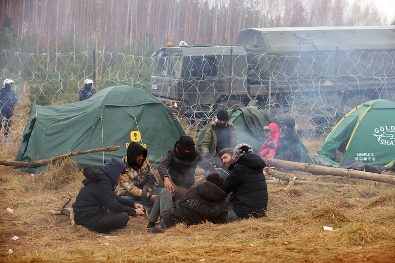 Migrants are surrounded by barbed wire at a camp at the Belarus/Poland border. AFP