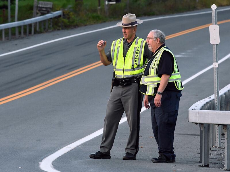 A New York state trooper and a member of the National Transportation Safety Board view the scene of the accident. AP Photo