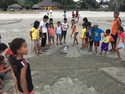 Nathaniel Alapide in the Philippines teaching children how to create sand art. Nathaniel Alapide