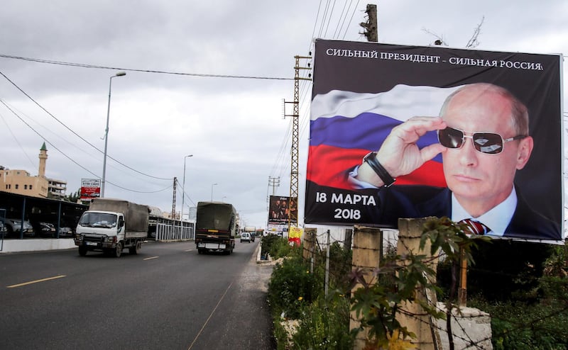 A picture taken on March 9, 2018 along a highway in the southern Lebanese coastal city of Tyre shows an electoral billboard for Russian President Vladimir Putin wearing sunglasses with lettering in Russian reading "Strong President, Strong Russia, 18 March 2018", for the Russian diaspora in the city to vote in the election scheduled on the same date. (Photo by Mahmoud ZAYYAT / AFP)