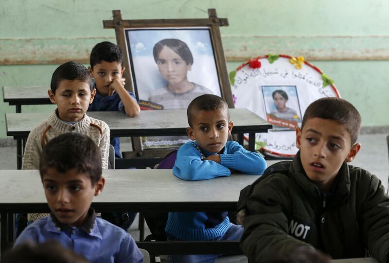 Palestinian pupils sit in class with a commemorative picture in the seat of their late classmate Moaz Abu Malhous at his school in Deir al-Balah town in central Gaza Strip, two days after he was reportedly killed in an Israeli strike. AFP