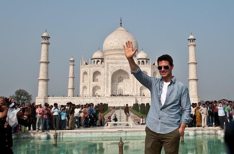 US Hollywood actor Tom Cruise waves as he poses at the Taj Mahal in Agra on December 3, 2011. Hollywood superstar Tom Cruise has arrived in India to promote the fourth installment of his blockbuster Mission: Impossible series. Sporting a big grin and sunglasses, the actor who is on a worldwide promotional tour for the movie, told reporters in the Indian capital he was 'very excited to be here' as cameramen jostled to film him.   AFP PHOTO/Manan VATSYAYANA (Photo by MANAN VATSYAYANA / AFP)