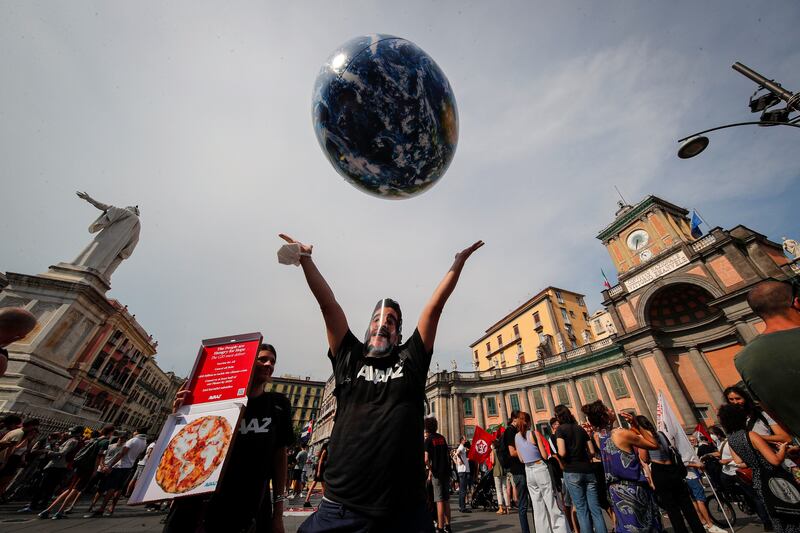 A protestor throws an inflatable globe into the air. Host Italy is hoping the talks will help spur ambitious goals to be adopted at the Cop26 conference in Glasgow.