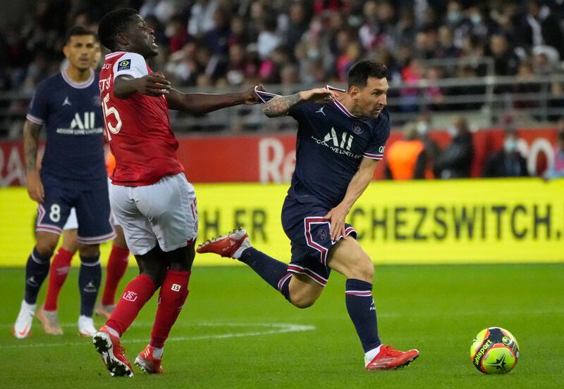Reims' Marshall Munetsi pulls the shirt of PSG debutant Lionel Messi during the Ligue 1 match at the Stade Auguste-Delaune on Sunday, August  29. AP