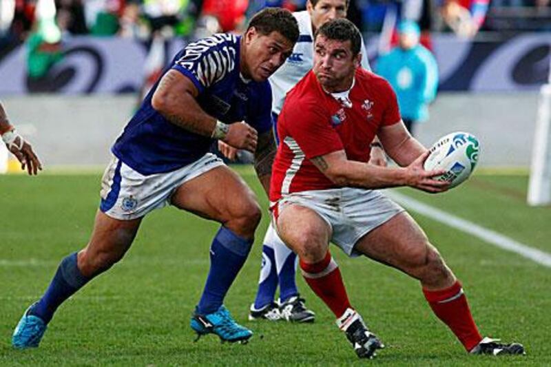 The Samoa captain, Mahonri Schwalger, moves in to tackle the Welsh hooker Huw Bennett during Wales' 17-10 win in Pool D of the Rugby World Cup.