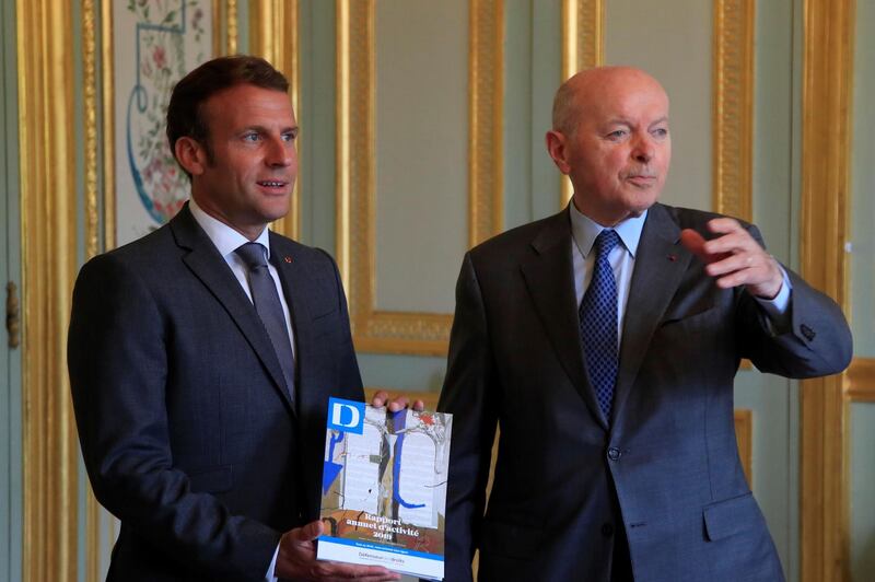 French President Emmanuel Macron (L) poses with the annual report handle by French Defender of the Rights Jacques Toubon (R) during a meeting at the Elysee Palace, in Paris,  on June 15, 2020. / AFP / POOL / Michel Euler
