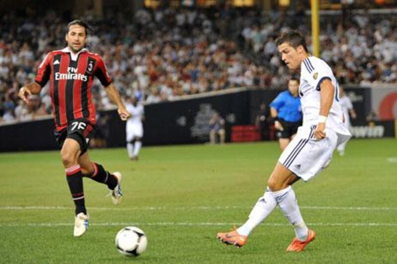 Cristiano Ronaldo knocks the ball past Milan's Mario Zepes to score his second at the Yankees Stadium