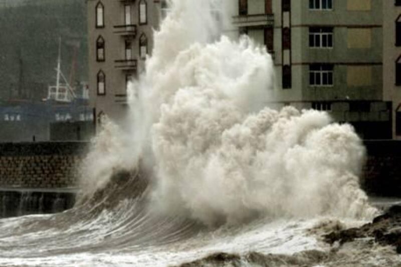 Waves crash into a waterfront wall in Zhangpu on October 23, 2010 in Fujian province. Torrential rain and gale-force winds lashed southern China as Typhoon Megi made landfall after killing at least 48 people as it roared through the Philippines and battered Taiwan as Chinese State television broadcast images of strong winds bending trees in the southeastern coastal province of Fujian, where billboards had toppled down and large waves whipped the coast. AFP PHOTO

 *** Local Caption ***  484794-01-08.jpg