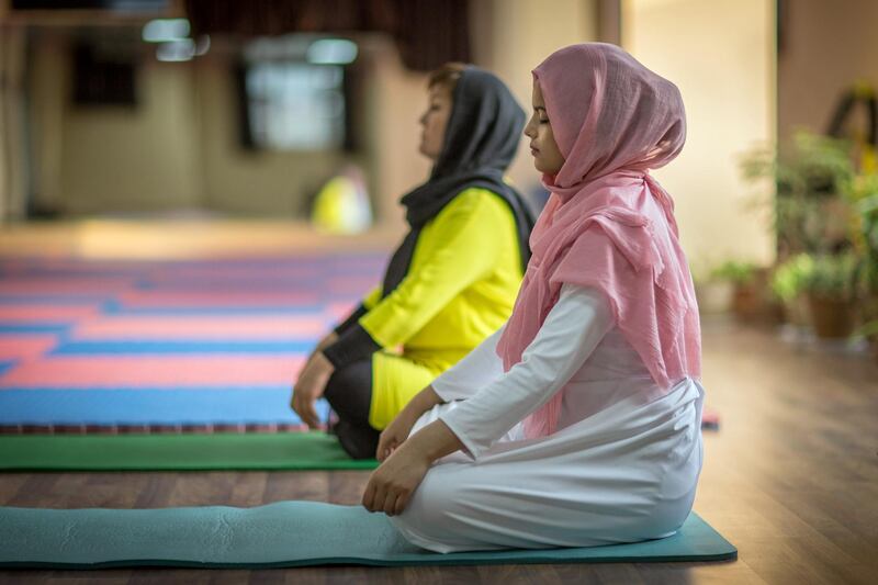Momtaz meditates at her yoga studio with one of her trainers in Kabul Afghanistan on January 17th 2018. Momtaz started teaching yoga about two years ago, at a women’s fitness club in Kabul. However the popularity for the art encouraged her to start her own specialised yoga centre in the war-torn capital of Afghanistan. Ivan Flores for The National