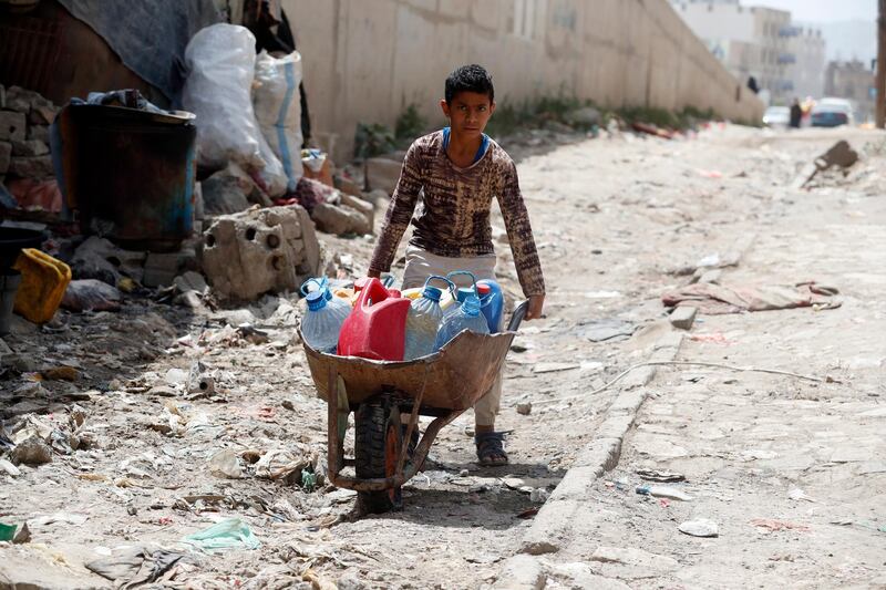 A displaced Yemeni boy pushes a wheelbarrow with water bottles after filling them from a charity tap, in Sanaa, Yemen. EPA
