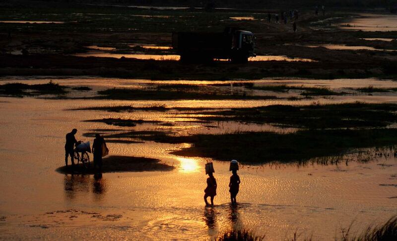 Indian villagers cross the Daya River as they return home after finishing daily marketing on a hot afternoon, on the outskirts of eastern Bhubaneswar, India. Asit Kumar / AFP