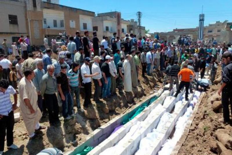 People gather at a mass burial for the victims purportedly killed during an artillery barrage from Syrian forces in Houla in this handout image dated May 26, 2012. U.N. observers in Syria have confirmed that artillery and tank shells were fired at a residential area of Houla, Syria, where at least 108 people, including many children, were killed, the U.N. chief said on Sunday in a letter to the Security Council.   REUTERS/Shaam News Network/Handout (SYRIA - Tags: POLITICS CONFLICT TPX IMAGES OF THE DAY CIVIL UNREST) FOR EDITORIAL USE ONLY. NOT FOR SALE FOR MARKETING OR ADVERTISING CAMPAIGNS *** Local Caption ***  AMM09R_SYRIA-UN-BAN_0528_11.JPG