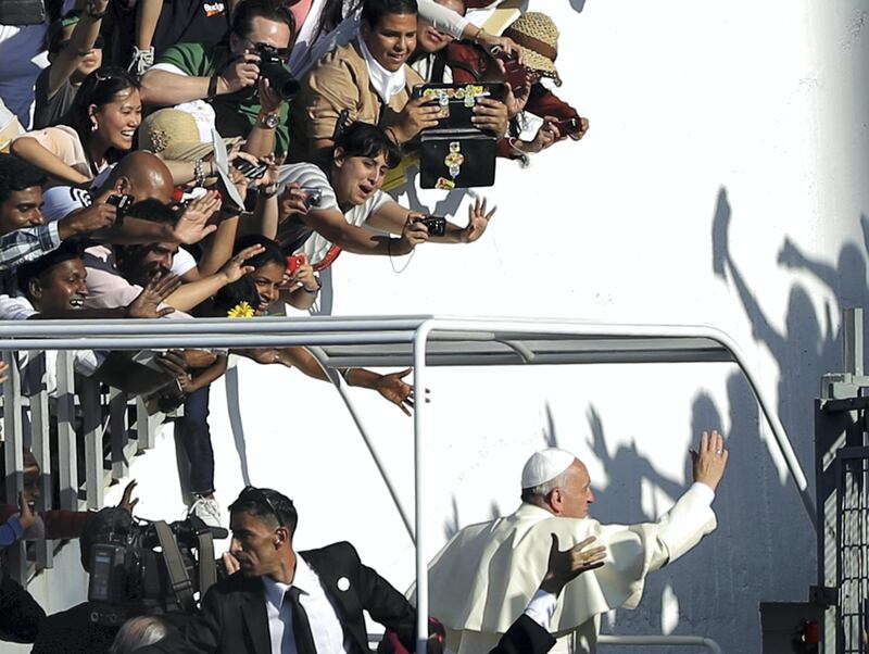 Pope Francis salutes the crowd as he leaves the stadium following a mass in Amman on May 24, 2014. Pope Francis made an urgent plea today for peace in war-torn Syria as he kicked off a three-day pilgrimage to the Middle East. AFP PHOTO / PATRICK BAZ (Photo by PATRICK BAZ / AFP)