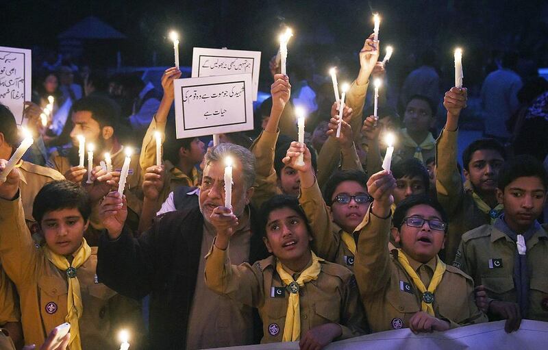 Pakistani teachers and students hold burning candles during a vigil to pay tribute to the victims of the Peshawar school massacre of December 16, 2014, as the country marks the first anniversary of the deadliest terror attack in its history. Arif Alo / AFP Photo