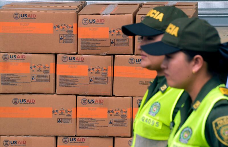 Colombian policewomen walk past boxes with US humanitarian aid goods in Cucuta, Colombia, on the border with Tachira, Venezuela, on February 8, 2019.
 Venezuelan military officers blocked a bridge on the border with Colombia ahead of an anticipated humanitarian aid shipment, as opposition leader Juan Guaido stepped up his challenge to President Nicolas Maduro's authority.
 / AFP / Raul ARBOLEDA
