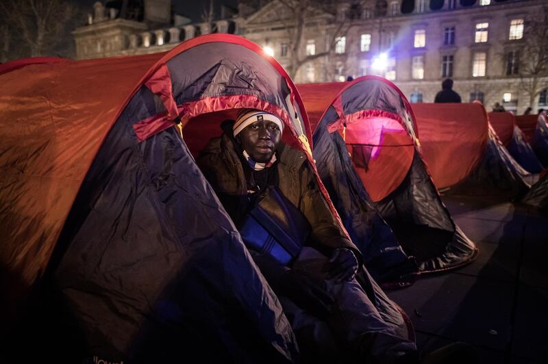 A man looks out from one of the tents set up on Place de la Republique. EPA