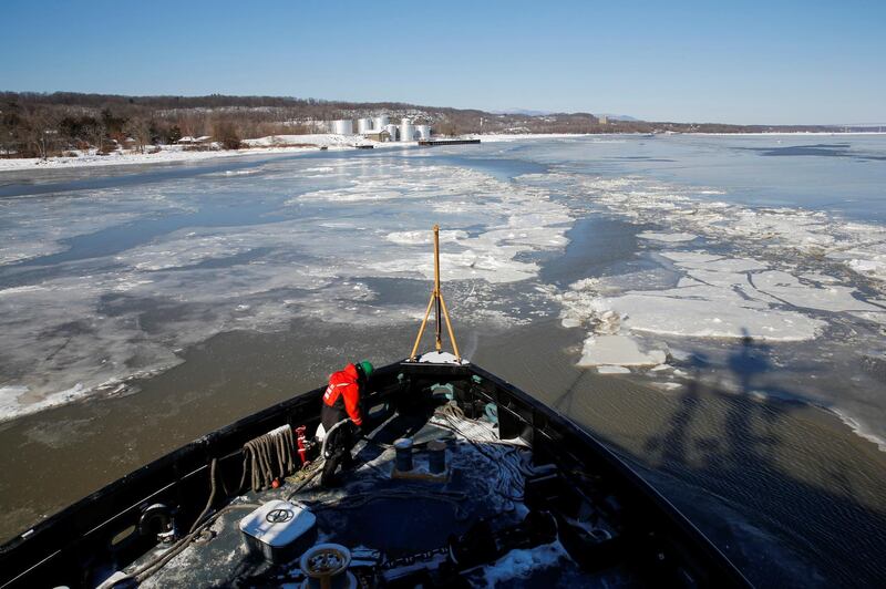 US Coast Guard members work on a boat used as an icebreaker during a polar vortex in New York.