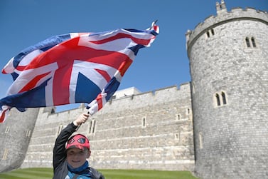 A boy holds a British flag in front of Windsor Castle as a report shows the UK's highly polarised views over foreign policy. EPA