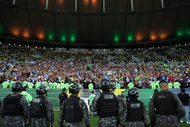 Argentina fans celebrate after the match as Brazilian police stand by from the pitch. Reuters