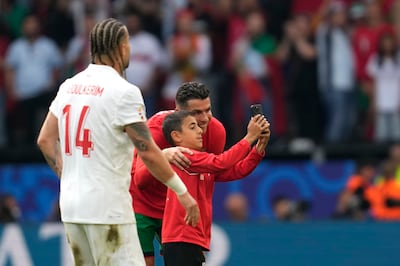 A young pitch invader takes a selfie with Portugal's Cristiano Ronaldo. AP