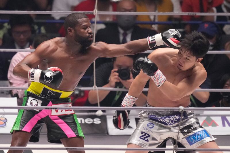 Boxer Floyd Mayweather of the U. S.  throws a punch against mixed martial artist Mikuru Asakura of Japan in Saitama, north of Tokyo, Sunday, Sept.  25, 2022.  (AP Photo / Hiro Komae)