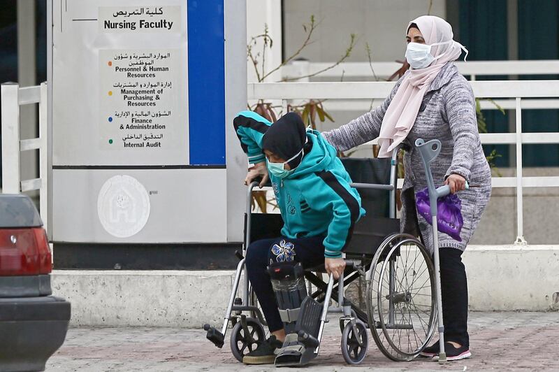 People wear face masks outside of the Rafik Hariri University Hospital where a woman is treated for coronavirus, the first case in Beirut, Lebanon.  EPA