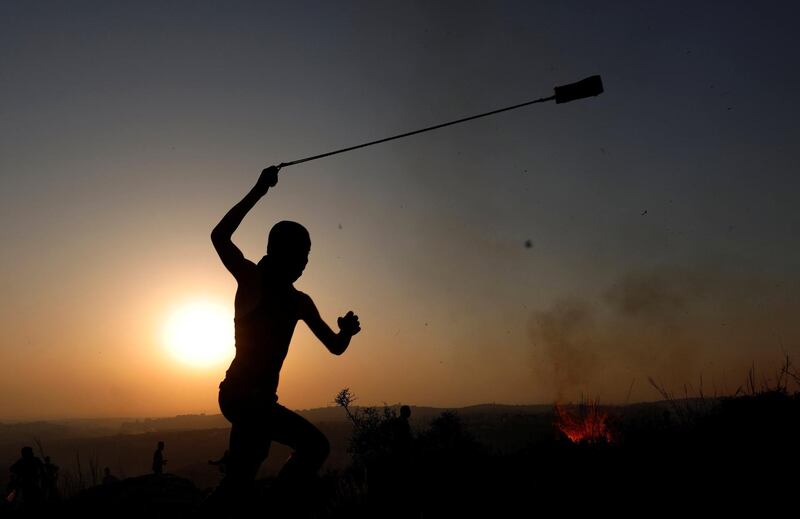 A Palestinian demonstrator uses a sling to hurl stones at Israeli troops in the village of Ras Karkar, near Ramallah in the occupied West Bank. Reuters