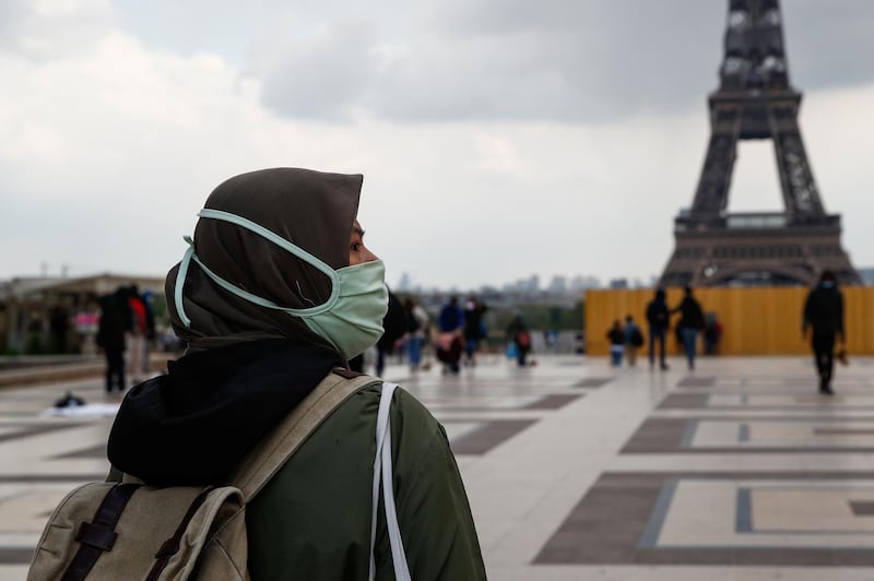 A woman, wearing a hijab and a protective face mask, walks at Trocadero square near the Eiffel Tower in Paris, France, May 2, 2021. Picture taken on May 2, 2021. REUTERS/Gonzalo Fuentes