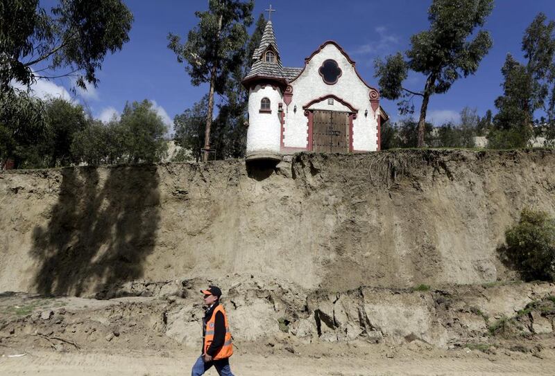 A worker walks in front of a chapel on February 29, 2016, after a landslide caused by heavy rain in Jupapina, on the outskirts of La Paz, Bolivia. 

David Mercado / Reuters