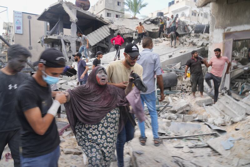 Palestinians evacuate survivors in Deir Al Balah after an Israeli bombardment. AP  