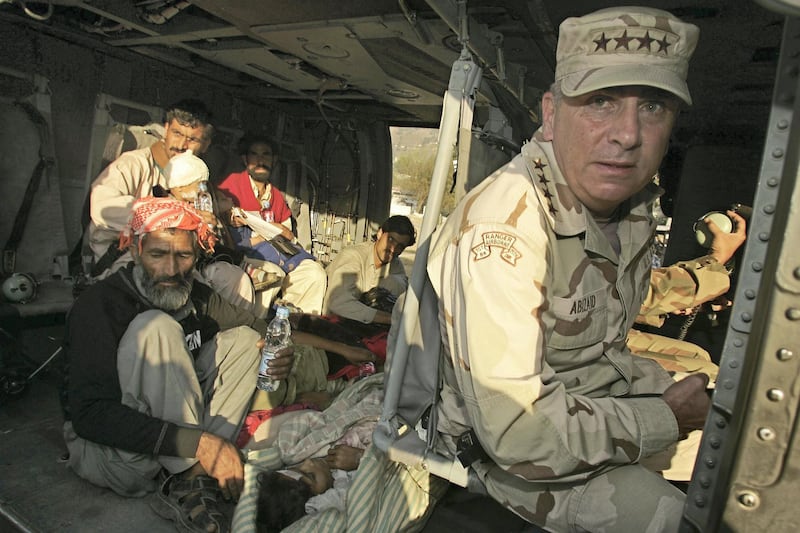 U.S. General John Abizaid, commander of the U.S. Central Command, sits aboard his helicopter about to leave Muzaffarabad, capital of Pakistan-administered Kashmir, October 23, 2005, with casualties from the South Asian earthquake. Abizaid pledged more U.S. support for relief efforts, saying the scope of the devastation was gigantic and the task ahead immense. Among the casualties who travelled with the general to the Pakistani capital Islamabad were a girl paralysed with a broken back (lying on floor in foreground) and a young boy whose mother was killed in the quake (far L). REUTERS/Zohra Bensemra - RP2DSFIXKHAA