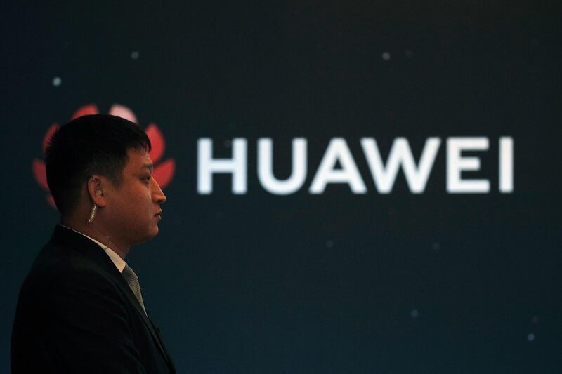 In this Jan. 9, 2019, photo, a security guard stands near the Huawei company logo during a new product launching event in Beijing. The Chinese Foreign Ministry said late Friday, Jan. 11, 2019, it is "closely following the detention of Huawei employee Wang Weijing" on charges of allegedly spying for China, and has asked Poland to "handle the case lawfully, fairly, properly and to effectively guarantee the legitimate rights of the person, his safety and his humanitarian treatment," according to state broadcaster CCTV. (AP Photo/Andy Wong)