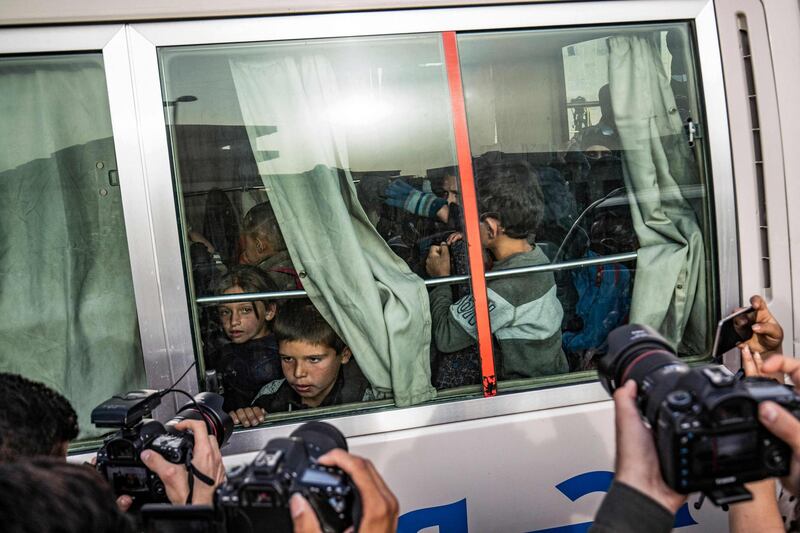 Children find themselves in the spotlight as they sit inside a bus during the handover of orphaned children of suspected ISIS fighters to a Russian delegation by Syrian Kurdish officials in Qamishli, north-east Syria. AFP