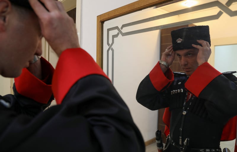 A member of the Circassian honour guards fixes his hat