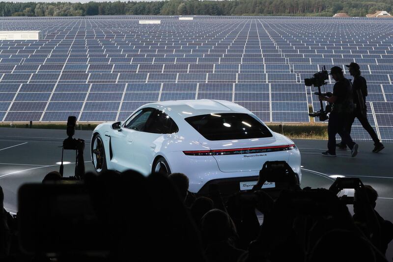 The all-electric Porsche AG Taycan luxury automobile stands on stage as it is unveiled beside the Solarhybrid AG solar park. Bloomberg