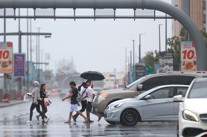 Abu Dhabi, United Arab Emirates, November 20, 2019.  
 UAE weather: rainfall and storms arrive at downtown Abu Dhabi.
--  Abu Dhabi residents cross the intersection of Hazza Bin Zayed The First St. and Sultan Bin Zayed The First St. during a rain shower.
Victor Besa / The National
Section:  NA
Reporter: