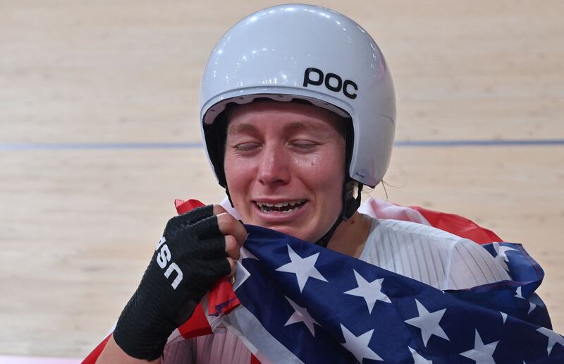 Gold medallist USA's Jennifer Valente reacts as she poses with a flag after the women's track cycling omnium points race.