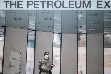 An Austrian Armed Forces soldier wearing a face mask patrols in front of the Opec headquarters in Vienna. The group reached a historic pact with the G20 to cut production. EPA