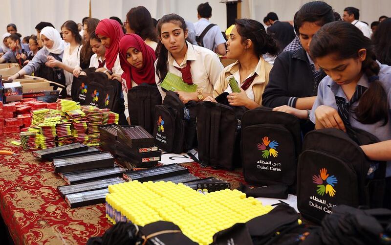Schoolchildren and volunteers from Dubai participate in packing bags with stationery kits for Palestinian children. Satish Kumar / The National