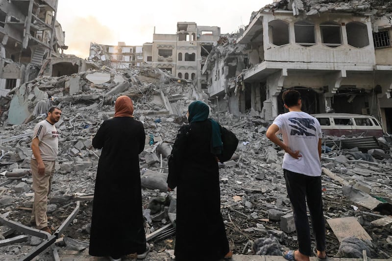 Palestinians inspect the massive destruction following Israeli air strikes on Gaza City's Al Rimal district. AFP