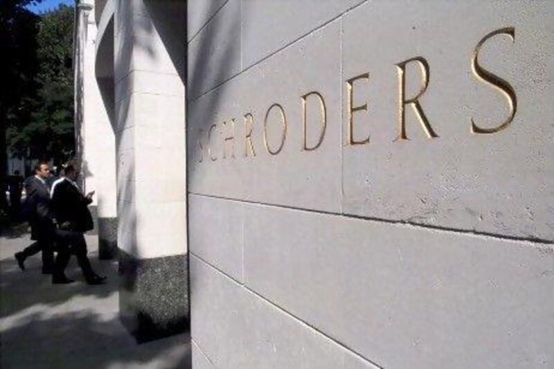 Businessmen enter the head office of Schroders in London’s financial district. The company will keep its presence in the UAE to build its regional business.