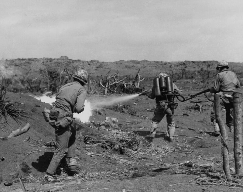 A US marine flame thrower operator in action, covered by a pair of riflemen, on Iwo Jima, February 1945. Reuters