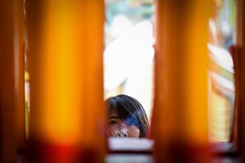 A woman prays in a Chinese temple in Bangkok, Thailand.  AFP