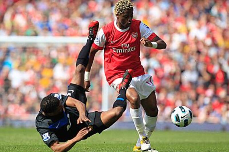 Arsenal’s Alex Song, right, upends Manchester United’s Patrice Evra during yesterday’s gritty clash yesterday.