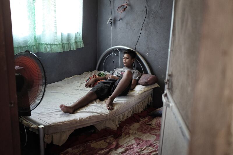 McNeil watches TV inside their house in Pampanga. A tense relationship with his dad, Ermando, emerged after McNeil’s mother left for work as a domestic helper in Dubai and he didn’t want to go to school. It prompted Ermando to join a new four-month programme that helps Filipino fathers deal with the challenges of having a wife who works abroad.