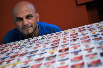 Gianni Bellini, owner of the largest Panini football stickers collection in the world, poses for a picture with collectable stickers by Panini in his studio in San Felice sul Panaro, Modena, on July 18, 2018. / AFP / Piero CRUCIATTI
