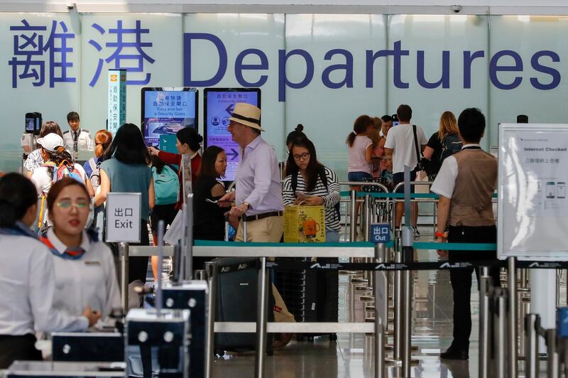 Airport staff help travellers near the departure gate at the airport in Hong Kong. AP Photo