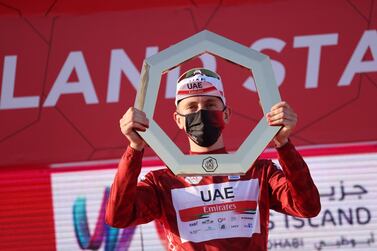 Tadej Pogacar of Team UAE Emirates celebrates on the podium after winning the UAE Cycling Tour from Yas Mall to Abu Dhabi Breakwater, on February 27, 2021. / AFP / Giuseppe CACACE